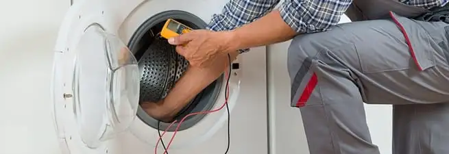 Dryer repair technician inspecting and repairing a clothes dryer in Akron, OH