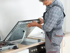 Appliance repair technician installing a built-in cooktop in Akron, OH