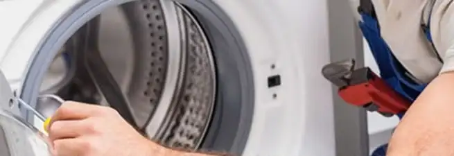 Appliance technician repairing a clothes dryer drum and internal parts in Akron, OH