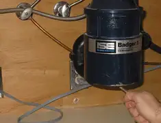 Garbage disposal repair technician tightening the mounting ring under a sink in Akron, OH