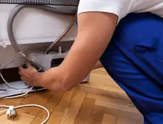 Appliance repair technician fixing refrigerator water line and connections in Akron, OH