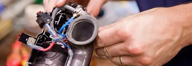 Vacuum repair technician reconnecting wiring and components in Akron, OH