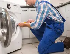 Washing machine repair technician servicing a front-load washer in Akron, OH
