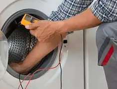Washing machine repair technician testing a front-load washer with diagnostic tools in Akron, OH