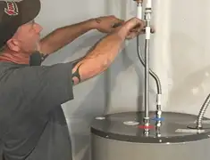 Water heater repair technician tightening supply line connections in Akron, OH
